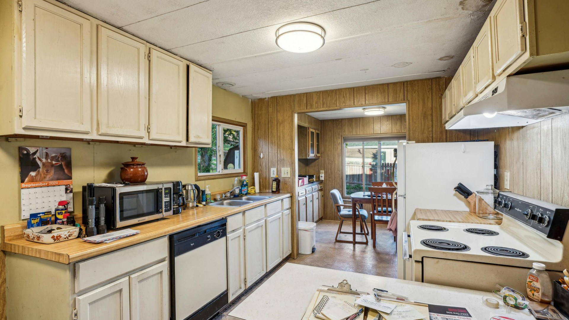 Older kitchen before renovation with dated cabinets and benchtops