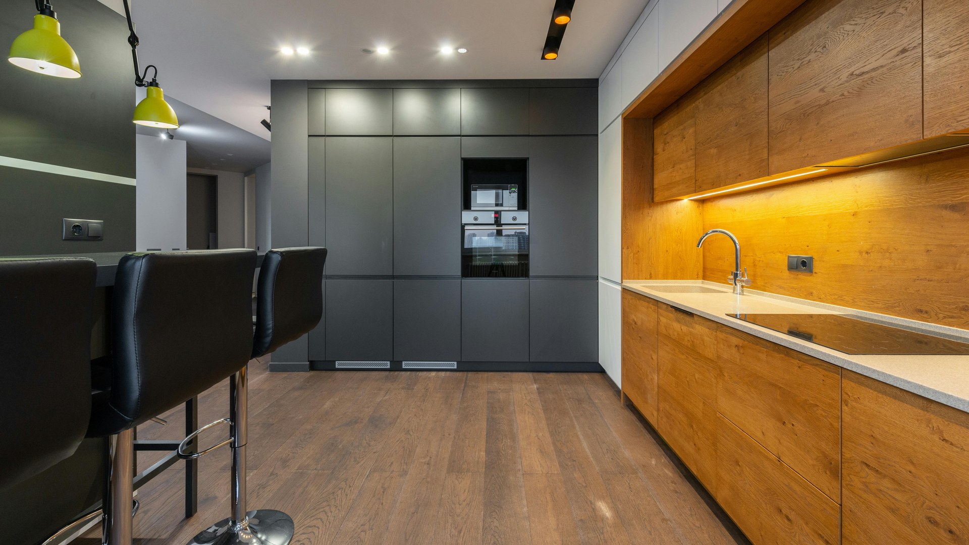 Modern real-life kitchen with timber cabinetry, dark feature wall and integrated appliances
